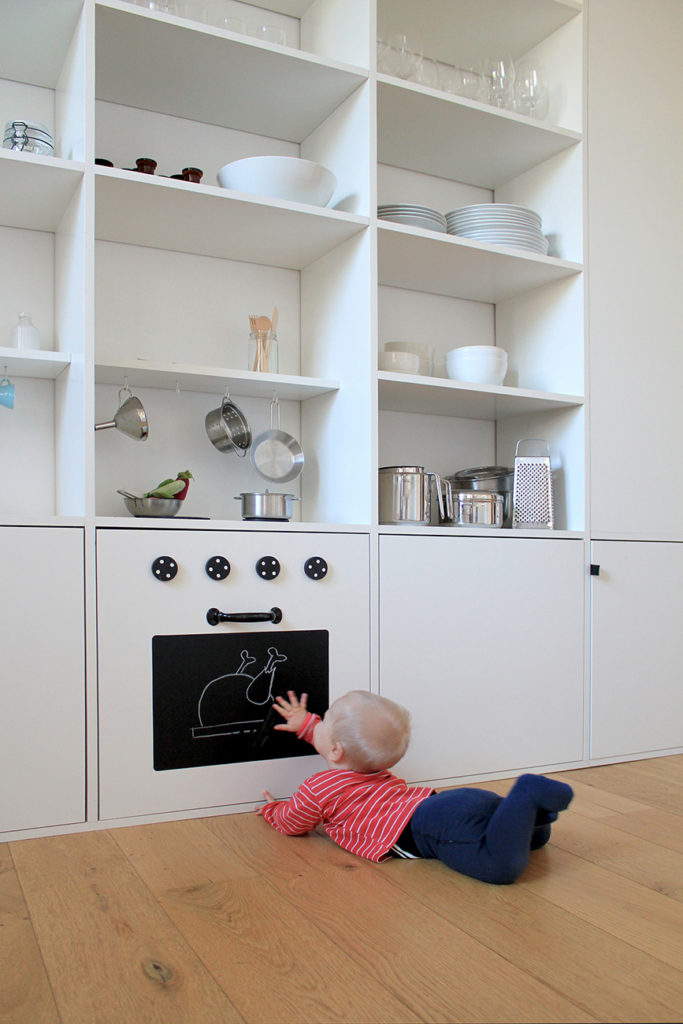 Eine Kinderküche eingebaut in ein Regal mit Herd, Ofen und Spüle
