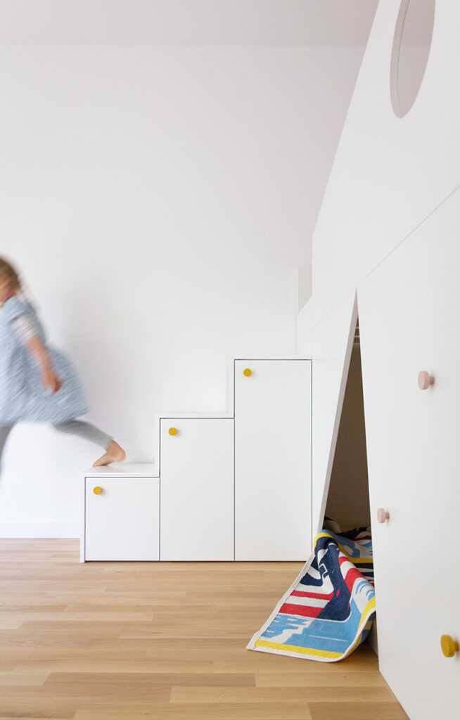 Ein IKEA TROFAST Regal ist einen Treppenschrank verwandelt worden und bildet den Aufgang zur oberen Ebene eines Hochbetts im Kinderzimmer.